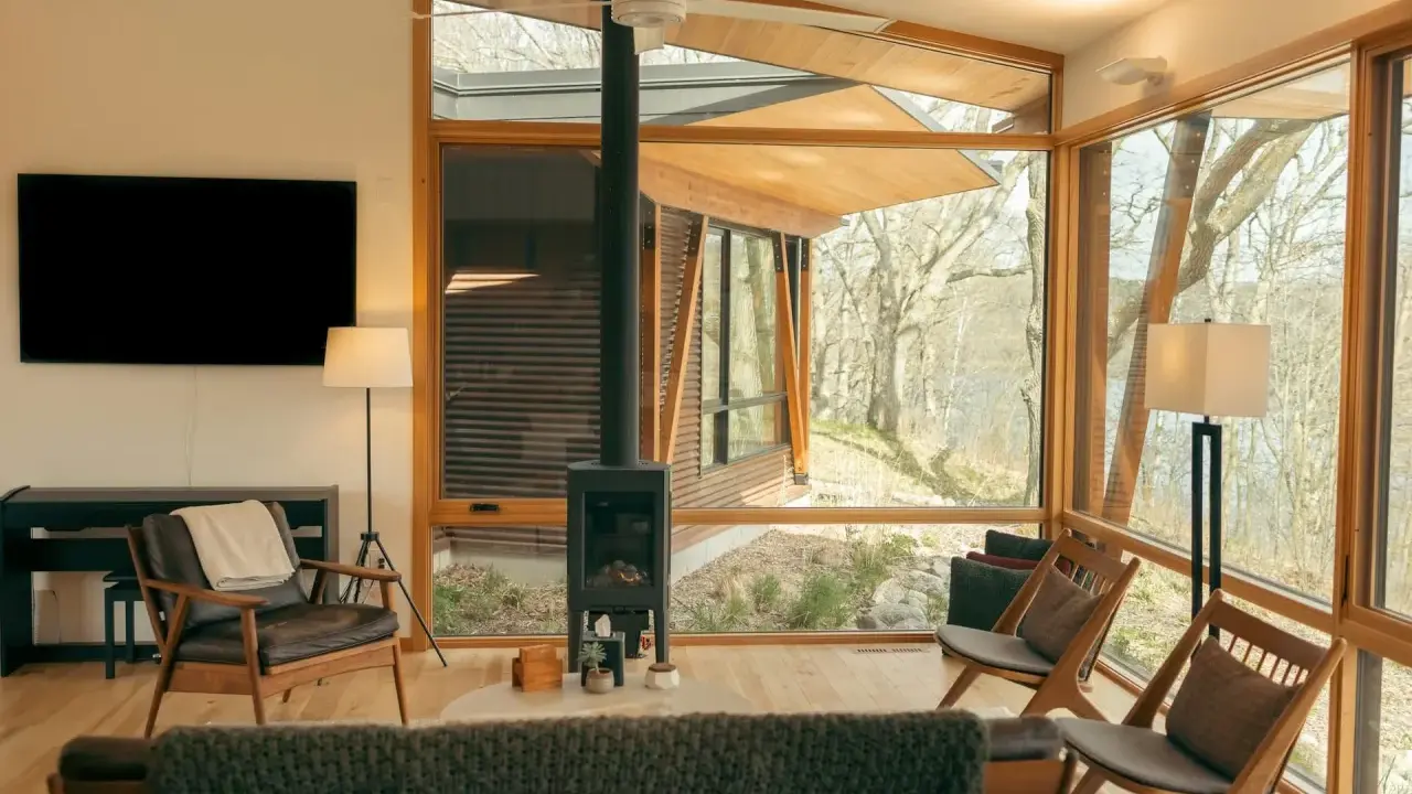 Salon moderne avec poêle à granulés 8 kw. Combien de m2 peut-il chauffer ? Fenêtres panoramiques, mobilier design, vue sur la nature.
