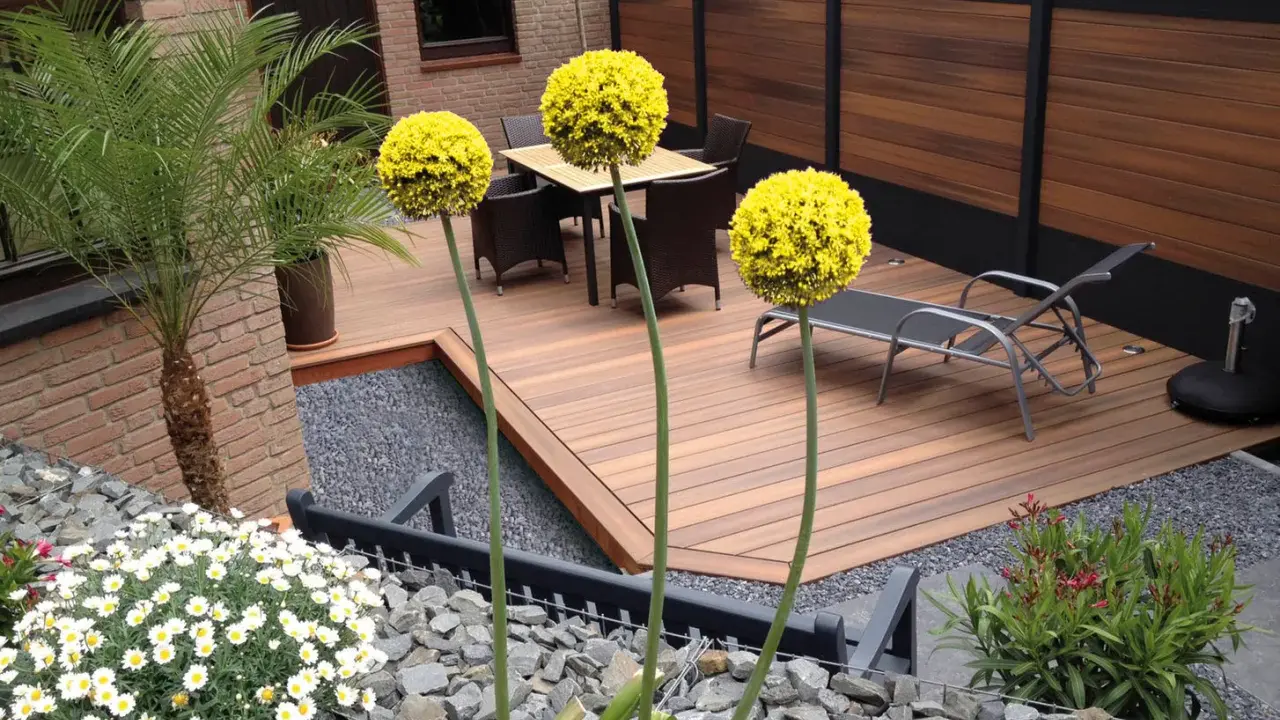 Giardino moderno con deck in legno, ghiaia e fiori gialli. Ottime idee giardino senza prato per un'oasi di relax.