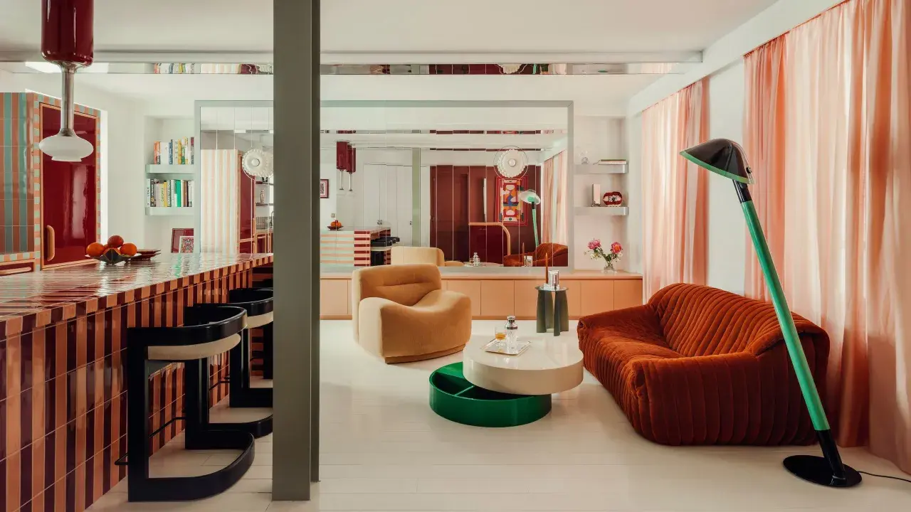 Un soggiorno con mobili colorati e un bancone da bar a righe. Stanza particolari in una casa che invita al relax e alla convivialità.