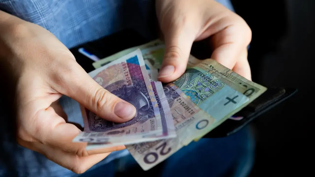 Ręce liczą banknoty, zastanawiając się, ile lat pracy do emerytury.