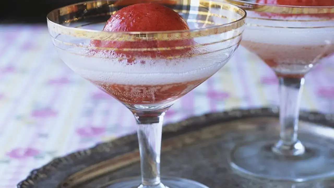 Zwei Gläser Champagner mit Erdbeeren, die auf einem Silbertablett stehen. Ein erfrischender Genuss.