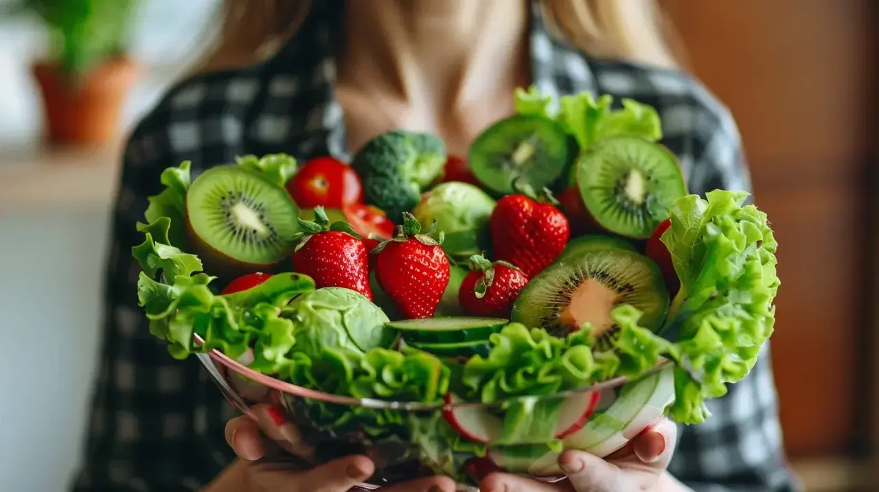 Miseczka pełna świeżych owoców i warzyw, jak kiwi, truskawki, pomidorki, sałata. Czy to zdrowa dieta, czy już ortoreksja?