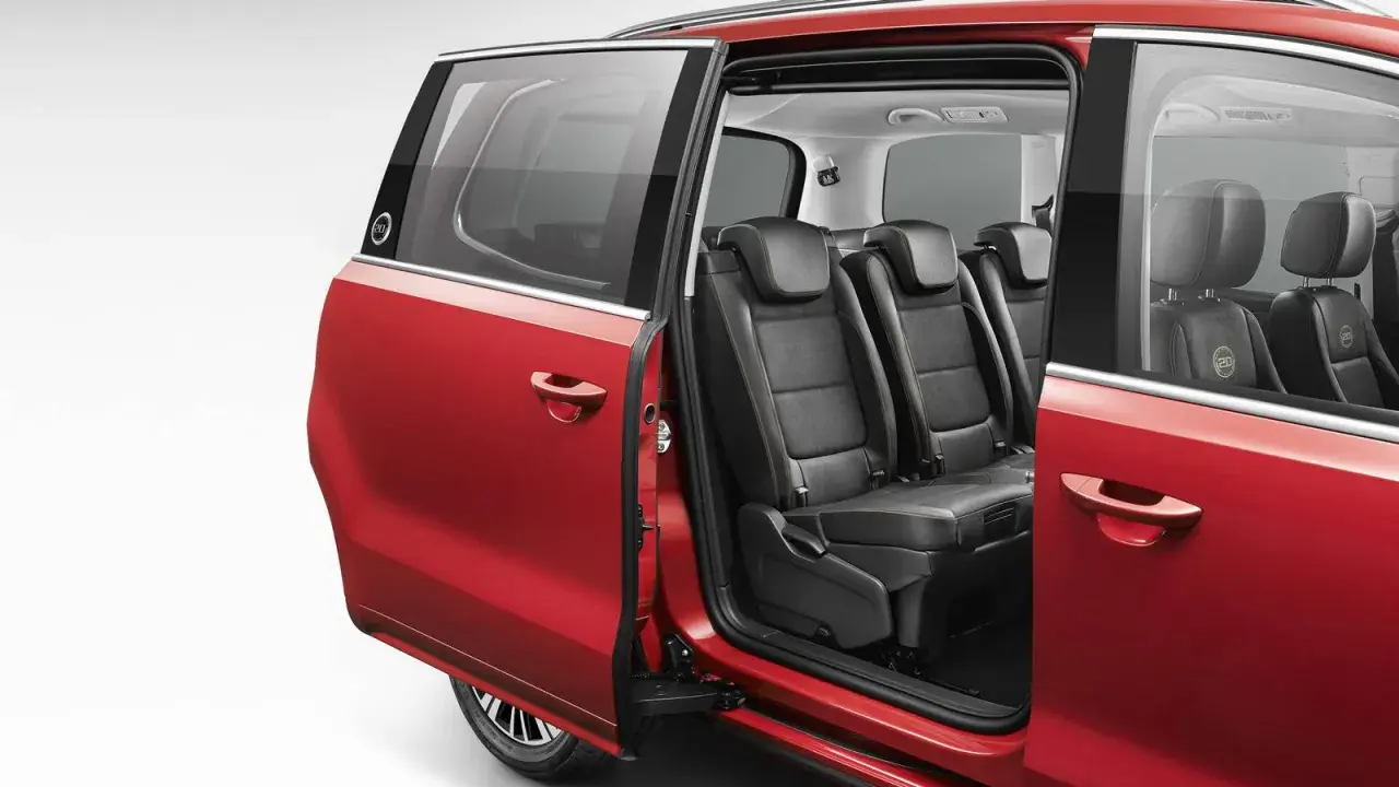 Interior de coches con puertas correderas rojas, mostrando asientos de cuero negro y detalles de costura.