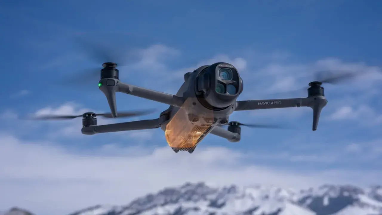 Mavic 4 Pro w locie, sterowany przez aplikację dji fly. W tle ośnieżone góry i błękitne niebo.