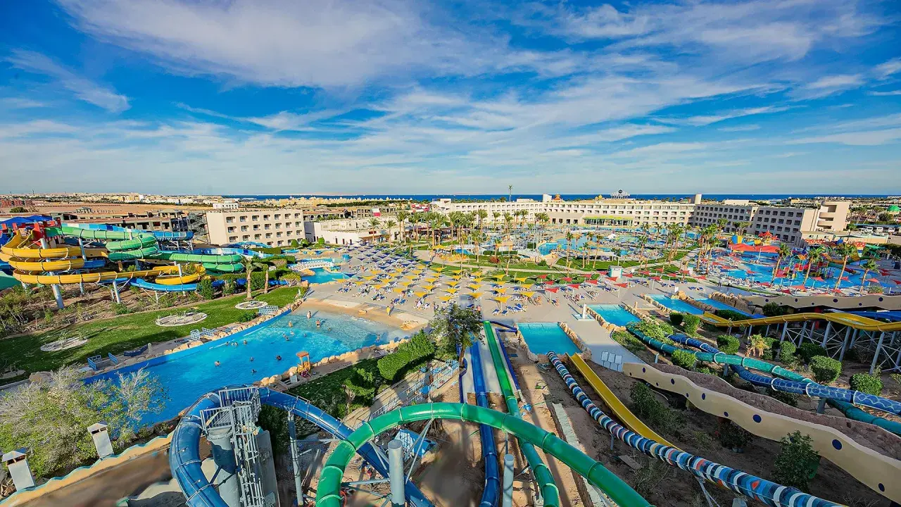 Wodne szaleństwo w Titanic Resort & Aquapark! Kolorowe zjeżdżalnie, baseny i palmy pod błękitnym niebem.