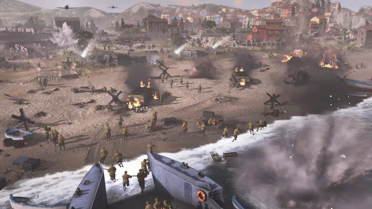 Desant na plażę w Company of Heroes. Żołnierze szturmują brzeg, płoną pojazdy, w tle miasto.