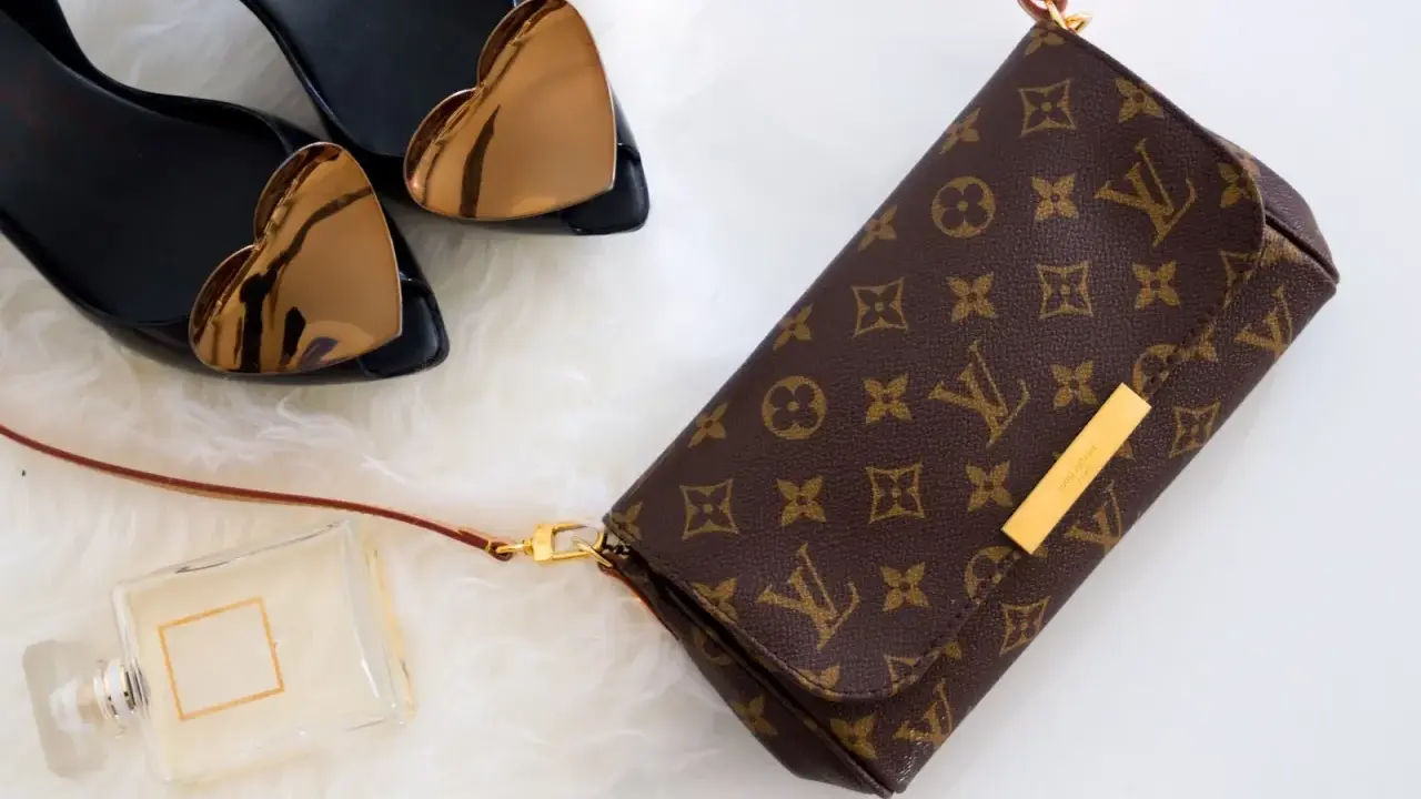 Torebka Louis Vuitton, czarne buty z sercami, perfumy na białym tle.