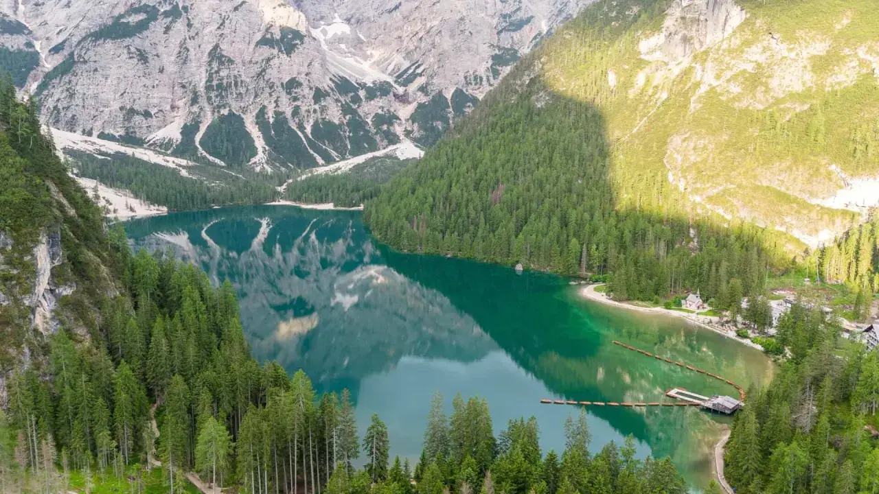 Un lago alpino dai riflessi smeraldo, incorniciato da boschi di conifere e montagne imponenti. Un gioiello tra i quattro laghi del nord Italia.