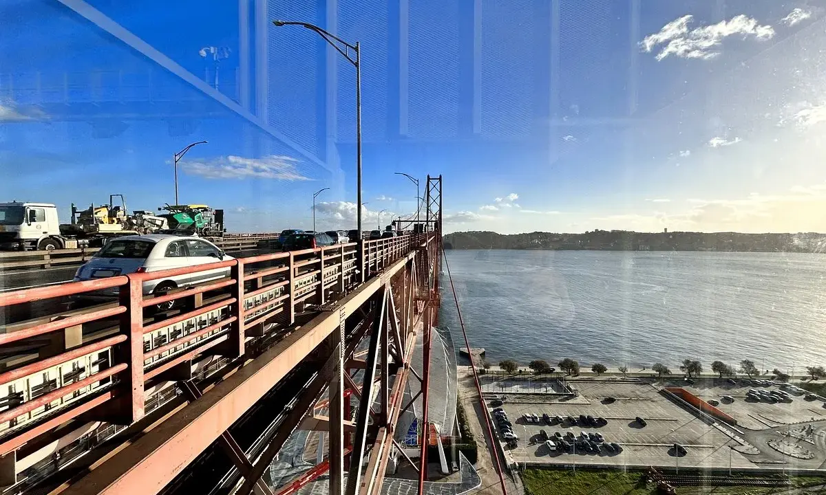 Autobahnverkehr auf der Brücke in Lissabon, mit Blick auf den Tejo und einen Parkplatz neben Pilar 7.