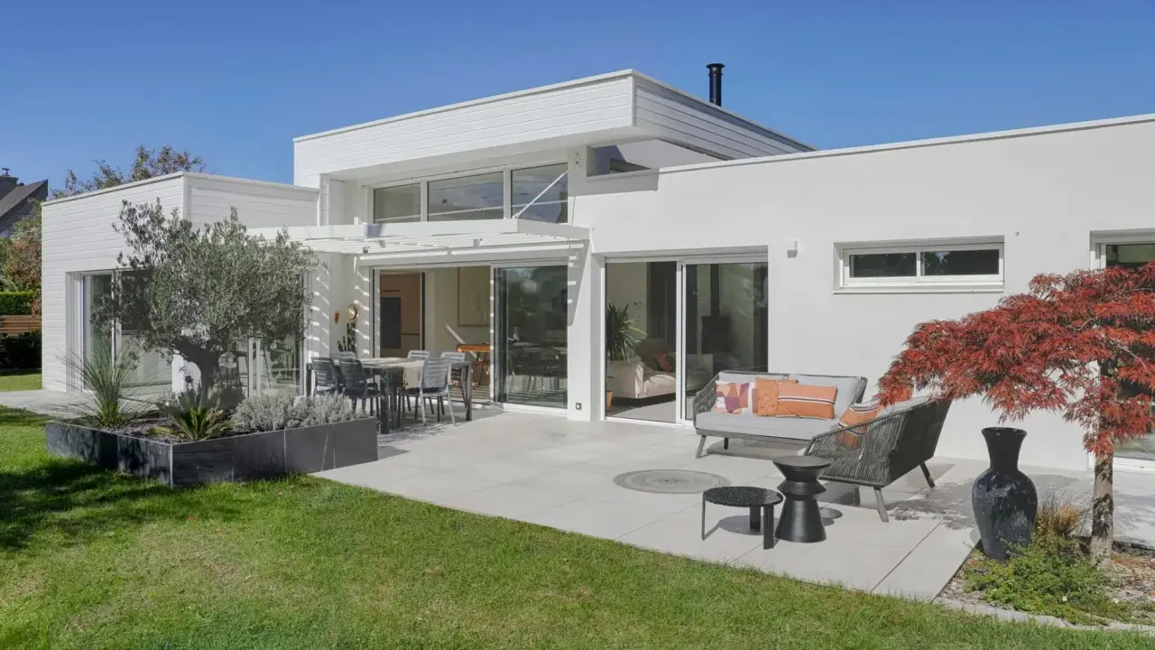 Maison moderne avec extension, terrasse aménagée. L'extension maison architecte obligatoire a créé un espace de vie lumineux et spacieux.