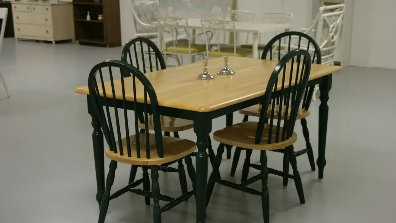 Drewniany stół z zielonymi krzesłami, idealny pomysł na jadalnie. Dwa świeczniki na blacie dodają elegancji.