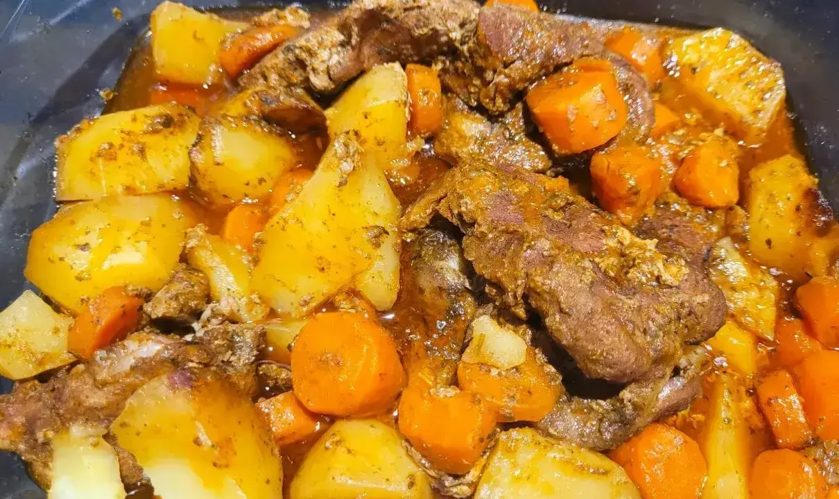 Pyszna karkówka po cygańsku z ziemniakami i marchewką w aromatycznym sosie. Danie wygląda na bardzo sycące i domowe.