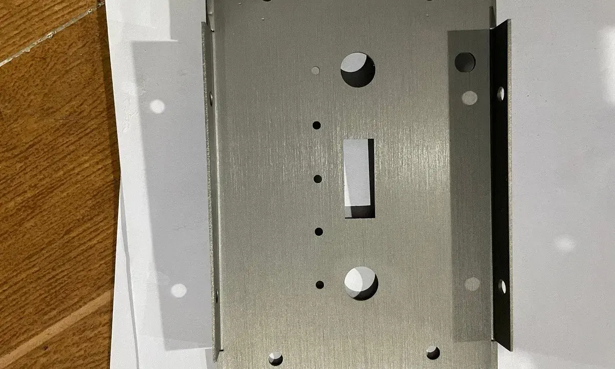 Plaque métallique en acier inoxydable 304l, avec des trous et une découpe rectangulaire, prête pour l'assemblage.