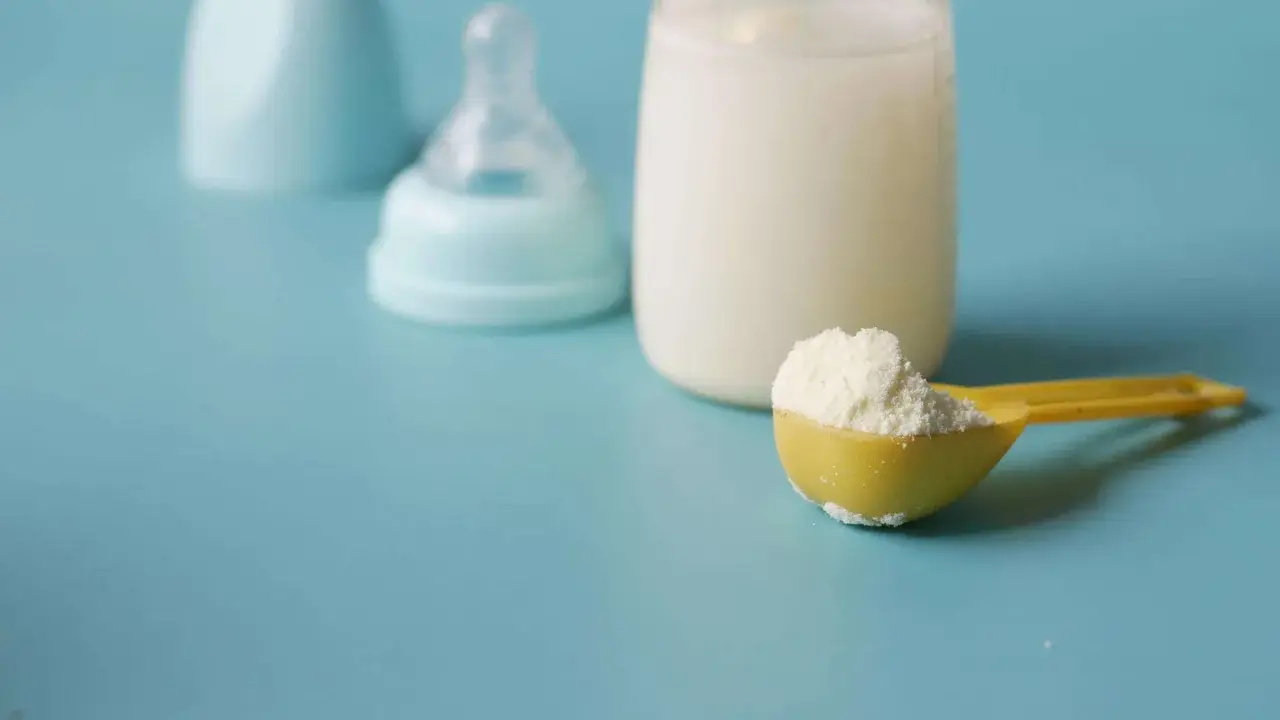 Biberon con latte, tettarella e misurino di latte in polvere, per capire quanto deve mangiare un neonato di 3 mesi.