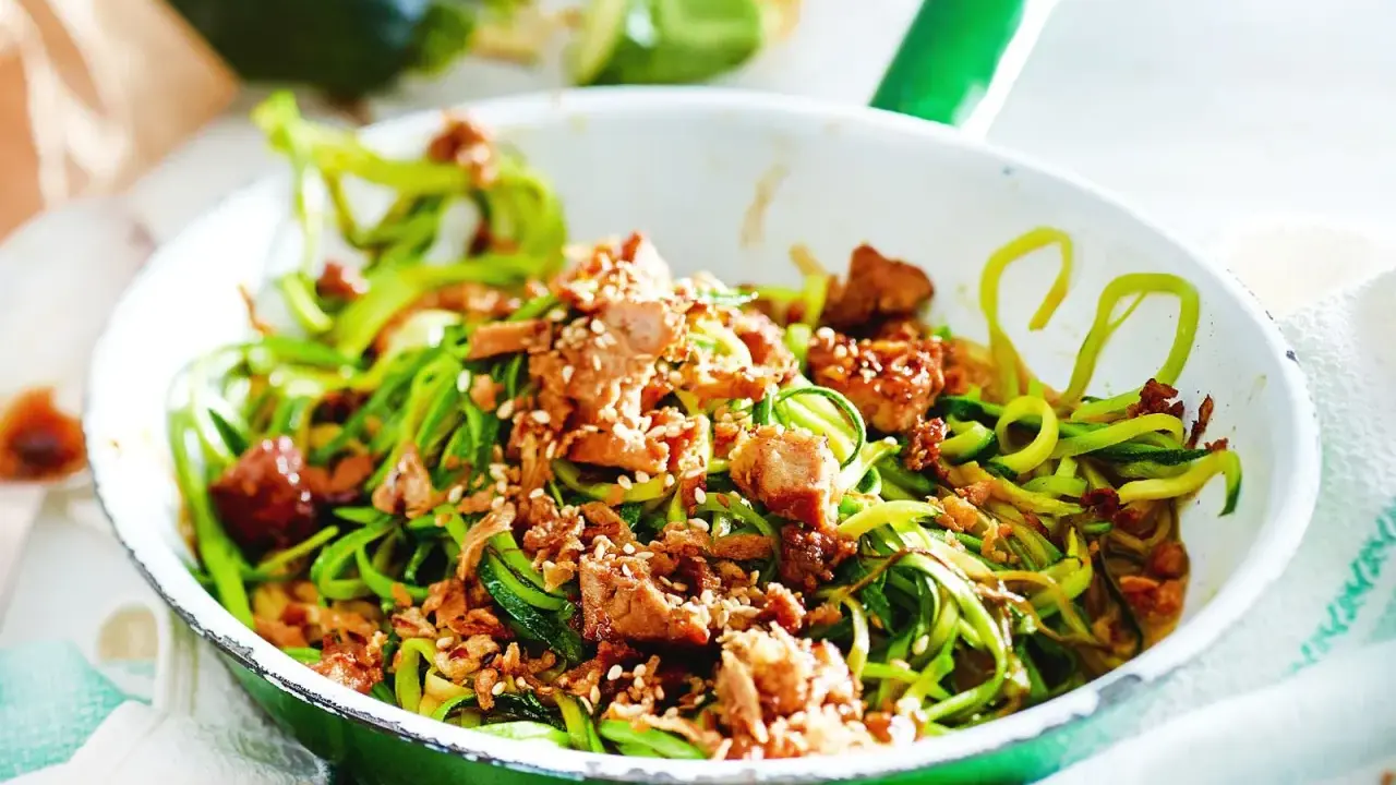 Zucchini-Nudeln mit Tofu und Sesam in einer Pfanne, ein leckeres low carb vegetarisch Gericht.