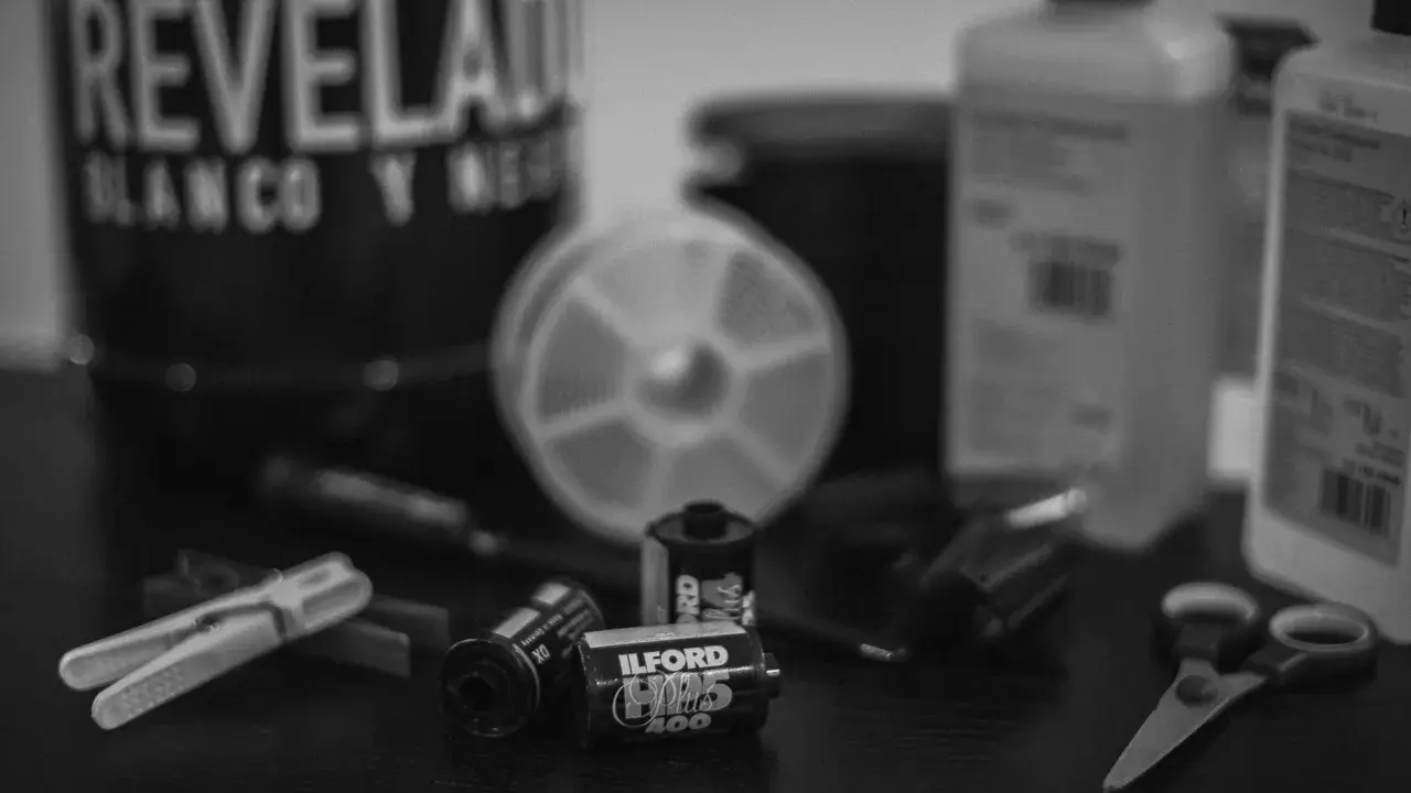 Utensilios para revelar fotos en blanco y negro: carretes Ilford, tijeras, pinzas y botes de químicos.