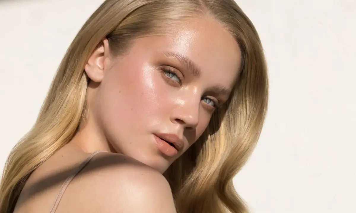 Delikatne rozjaśnianie brwi podkreśla naturalne piękno blondynki. Jej skóra lśni w słońcu.