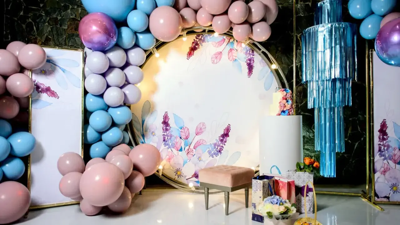 Jak udekorować salę na 18 urodziny? Balony, kwiaty i elegancka ścianka z motywem roślinnym stworzą magiczną atmosferę.