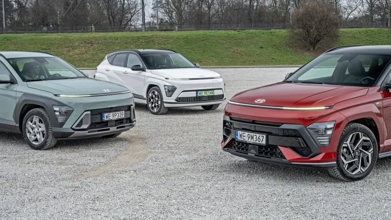 Trzy nowe Hyundai w różnych kolorach: zielony, biały i czerwony, zaparkowane na żwirowym placu.