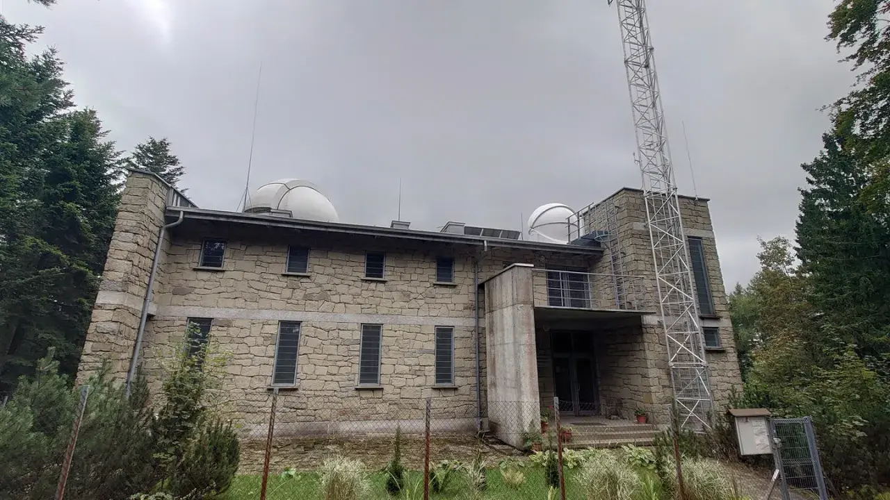 Kamienny budynek obserwatorium na szczycie góry, z kopułami teleskopów i wieżą telekomunikacyjną. To lubomirskie schronisko naukowców.