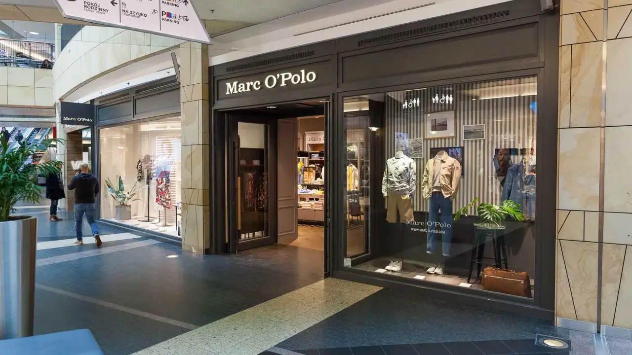 Sklep Marc O'Polo w centrum handlowym. Elegancka witryna prezentuje męskie ubrania, a w środku widać manekiny w stylowych strojach.