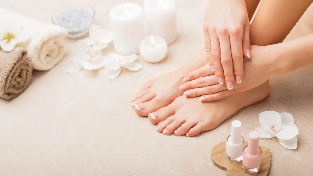 Piedi curati e mani perfette: il podologo fa la pedicure, con smalti rosa e bianchi pronti per un tocco finale.