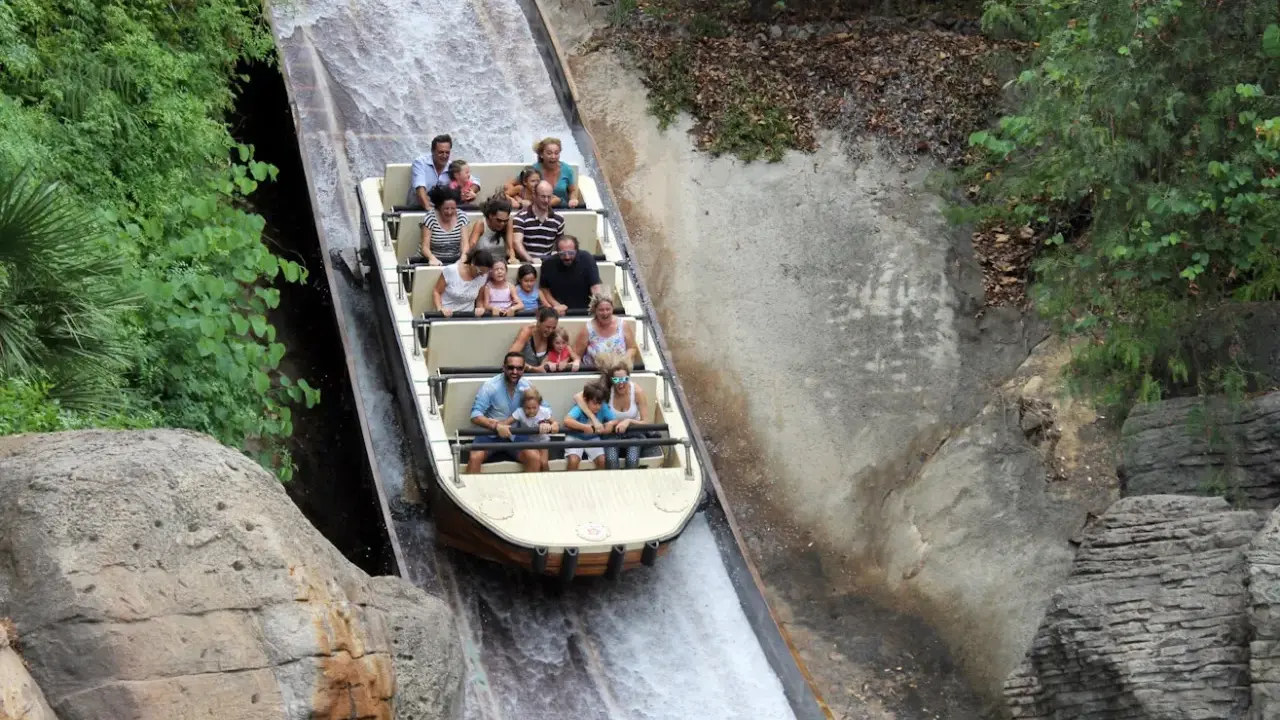 Bootsfahrt auf einer Wildwasserbahn, die durch eine üppige, grüne Landschaft führt. Die Menschen lachen und genießen die Fahrt auf der Isla Mágica.