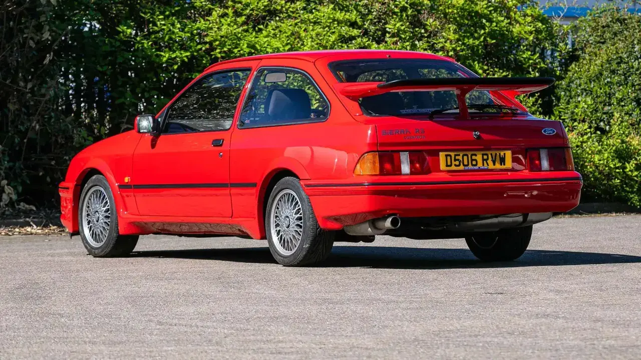 Roter Ford Sierra RS Cosworth mit großem Heckspoiler und markanten Felgen, bereit für die nächste Ausfahrt.