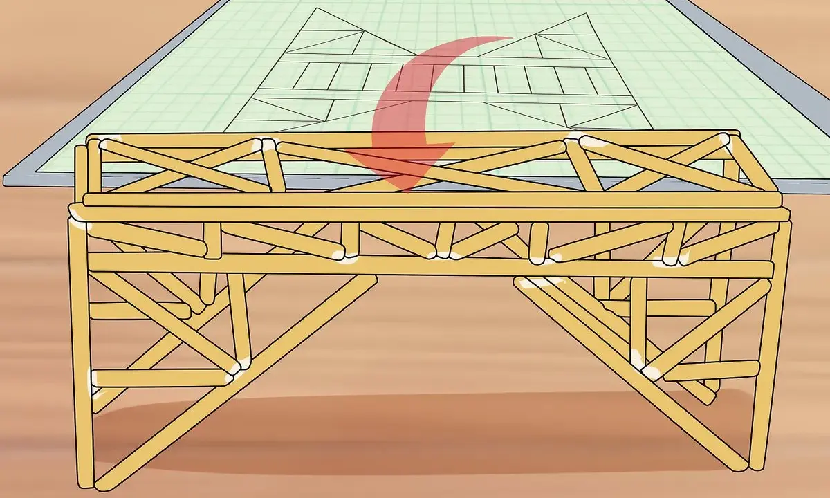 Un modelo de puentes de madera se construye sobre un plano de ingeniería.