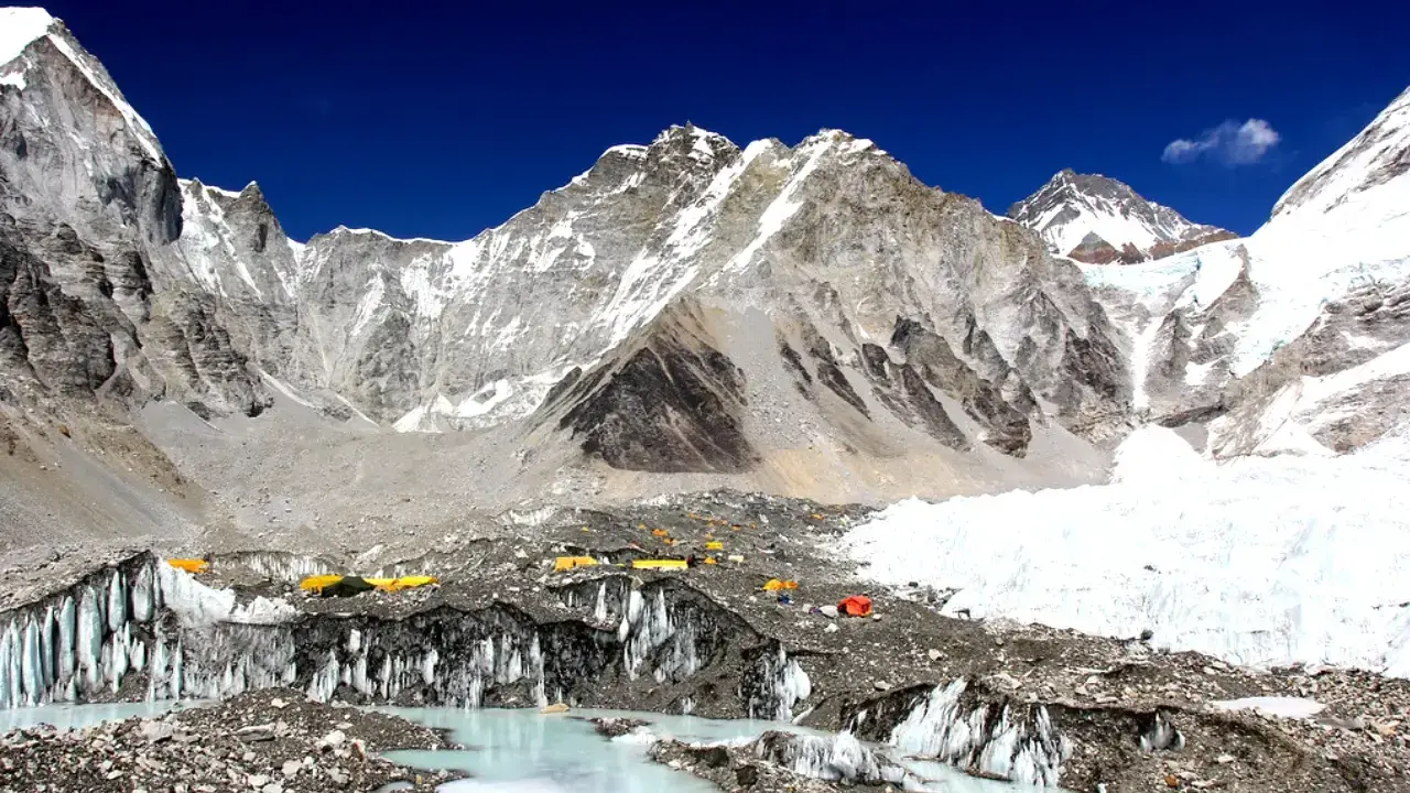 Niezwykły widok z bazy pod Mount Everest. Kolorowe namioty obozowe na tle lodowca i surowych, ośnieżonych szczytów. To początek ekscytującego **trekking pod Mount Everest**.