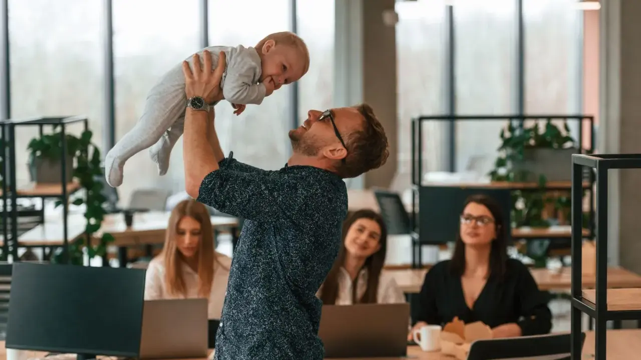 Ojciec podrzuca dziecko w biurze, podczas gdy koleżanki pracują. Czy urlop wychowawczy wlicza się do stażu pracy?