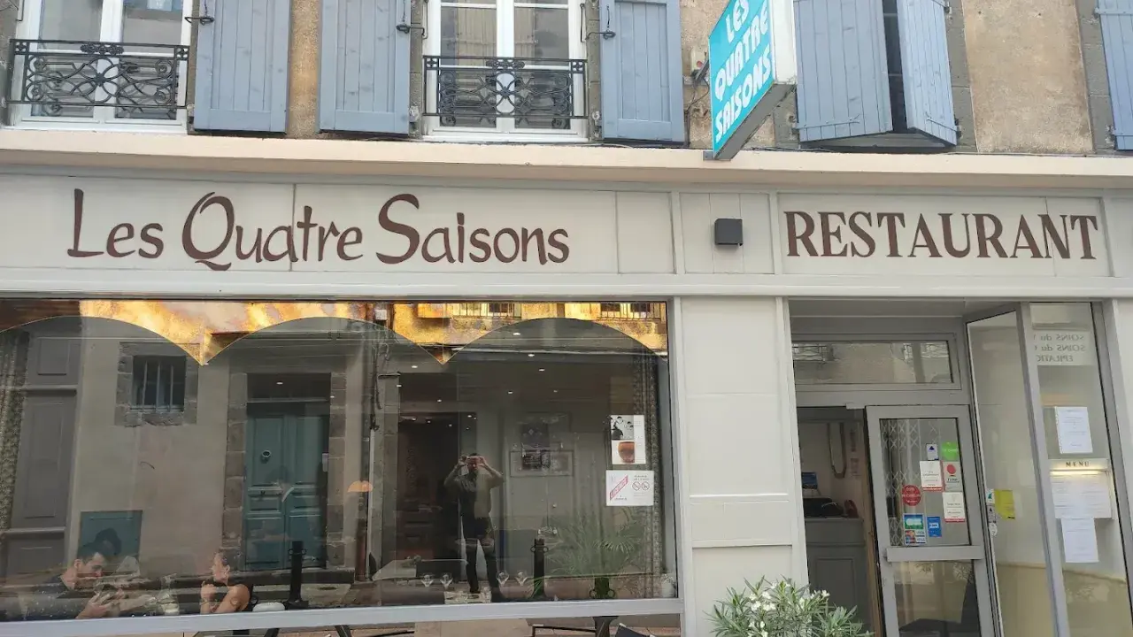 Le restaurant étoilé Les Quatre Saisons à Aurillac, une façade accueillante avec une enseigne lumineuse.
