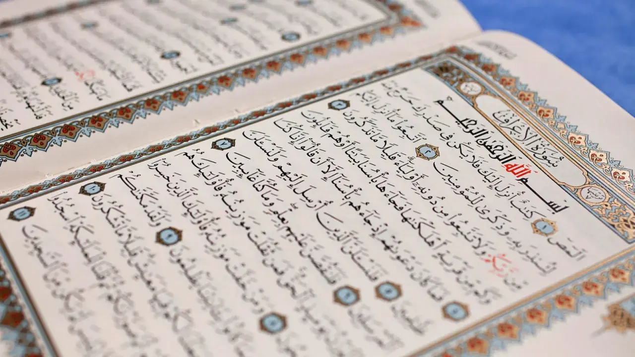 Ein aufgeschlagenes Korankonvolut mit arabischer Schrift und dekorativen Rändern. Es erinnert an die Lehren des Islams und die Geschichten von Jinn.