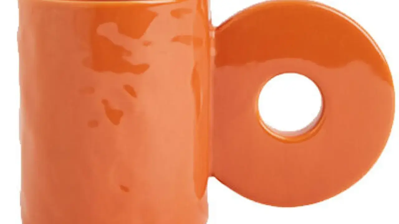 En orange mugg med ett cirkulärt handtag. Perfekt för ditt keramik hemma utan ugn-projekt.