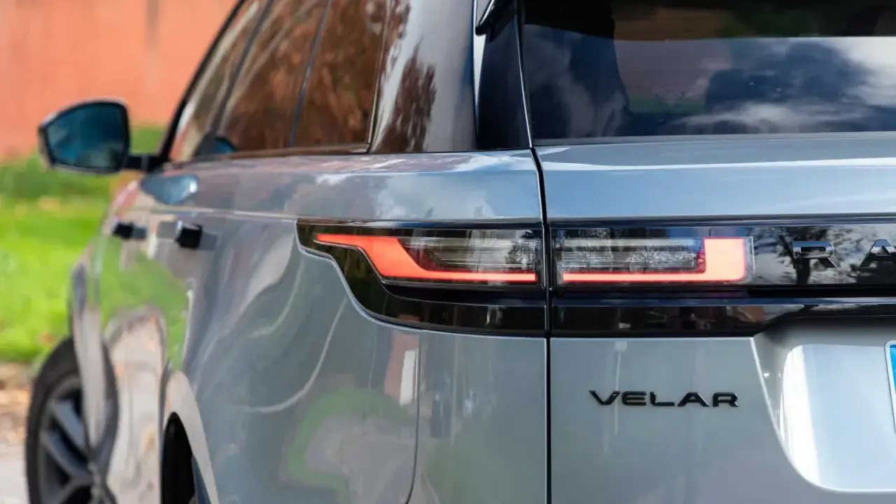 Detalle trasero de un Range Rover Velar plateado, mostrando sus luces LED y el emblema. Sus dimensiones son ideales para la ciudad y la aventura.