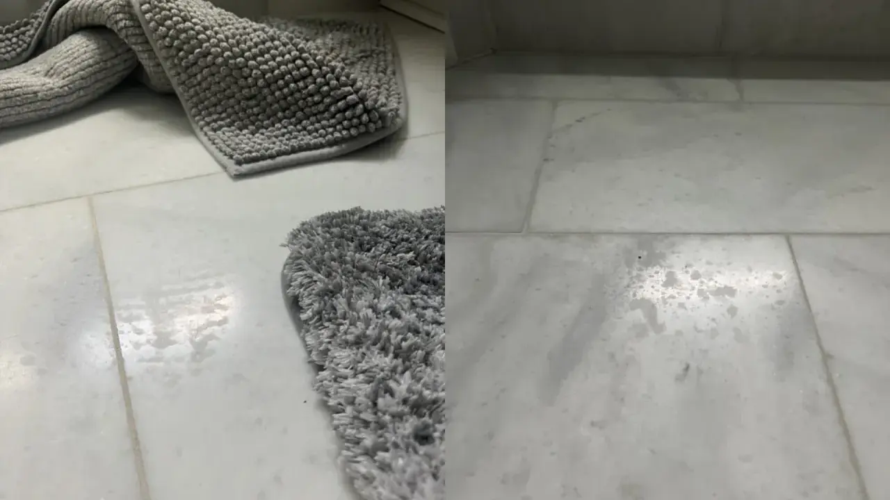 Grå badrumsmattor på marmorgolv. Vattenfläckar syns på golvet, vilket indikerar behov av marmor polering för att återställa glansen.
