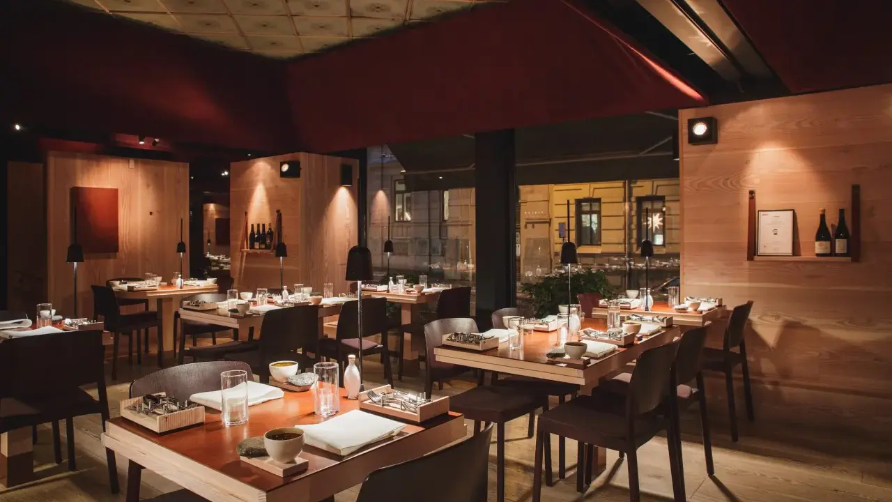 Elegant inredning på en michelin restaurang i Sverige. Vackert dukade bord med trädetaljer och dämpad belysning skapar en intim atmosfär.