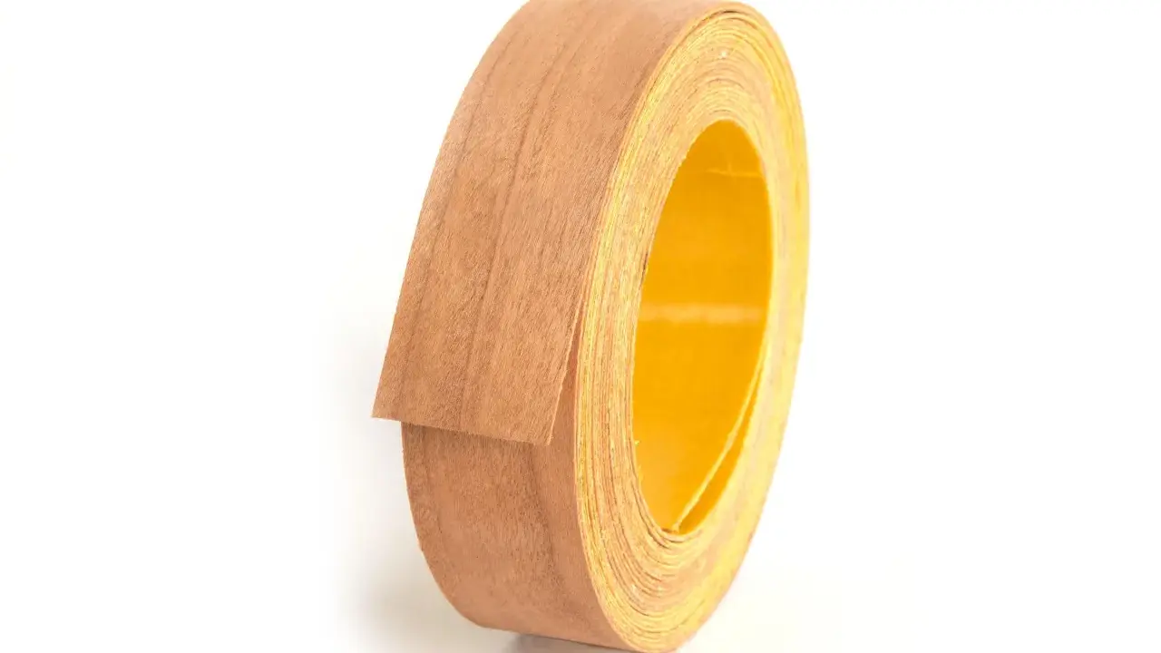 Rollo de cinta de cantear de madera con reverso amarillo, listo para embellecer muebles.