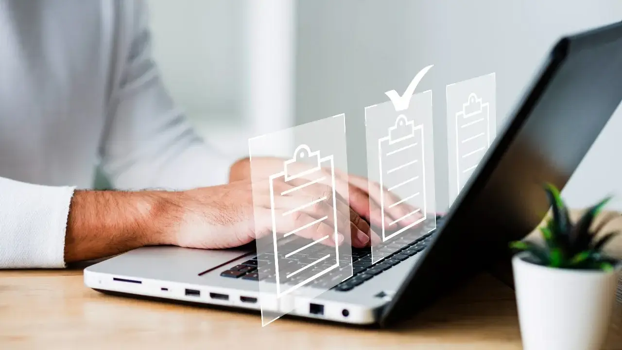 Man typing on laptop with digital checklists. It's important that es obligatorio registrar un contrato de alquiler.