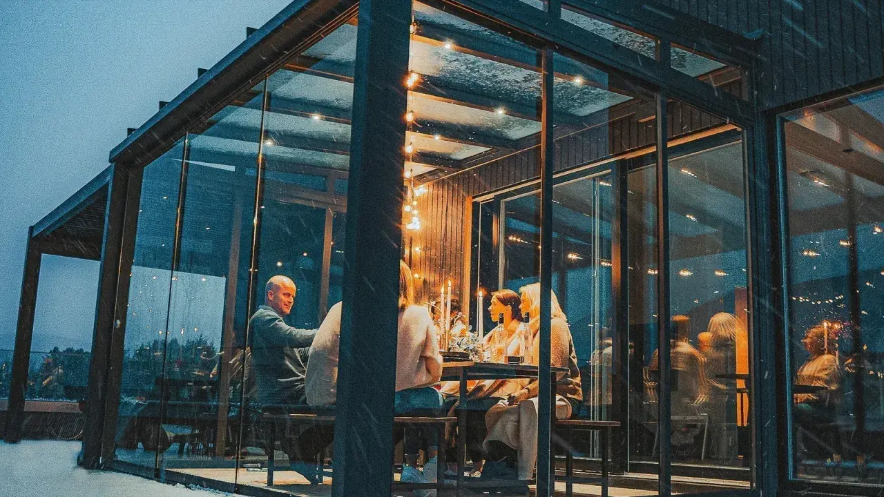 Gemütliches Abendessen im Glasanbau. Die Frage "was kostet ein Wintergarten" stellt sich hier angesichts der Atmosphäre nicht.