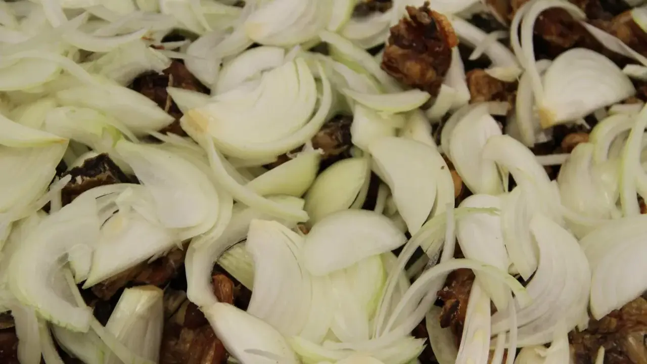 Oignons émincés et morceaux de viande brune, prêts à mijoter pour un délicieux jus de veau.