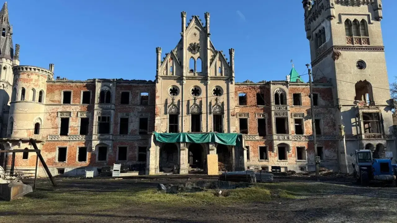 Ruiny pałacu w Kopicach, zniszczony zamek z ceglanymi ścianami i pustymi oknami, pod błękitnym niebem.