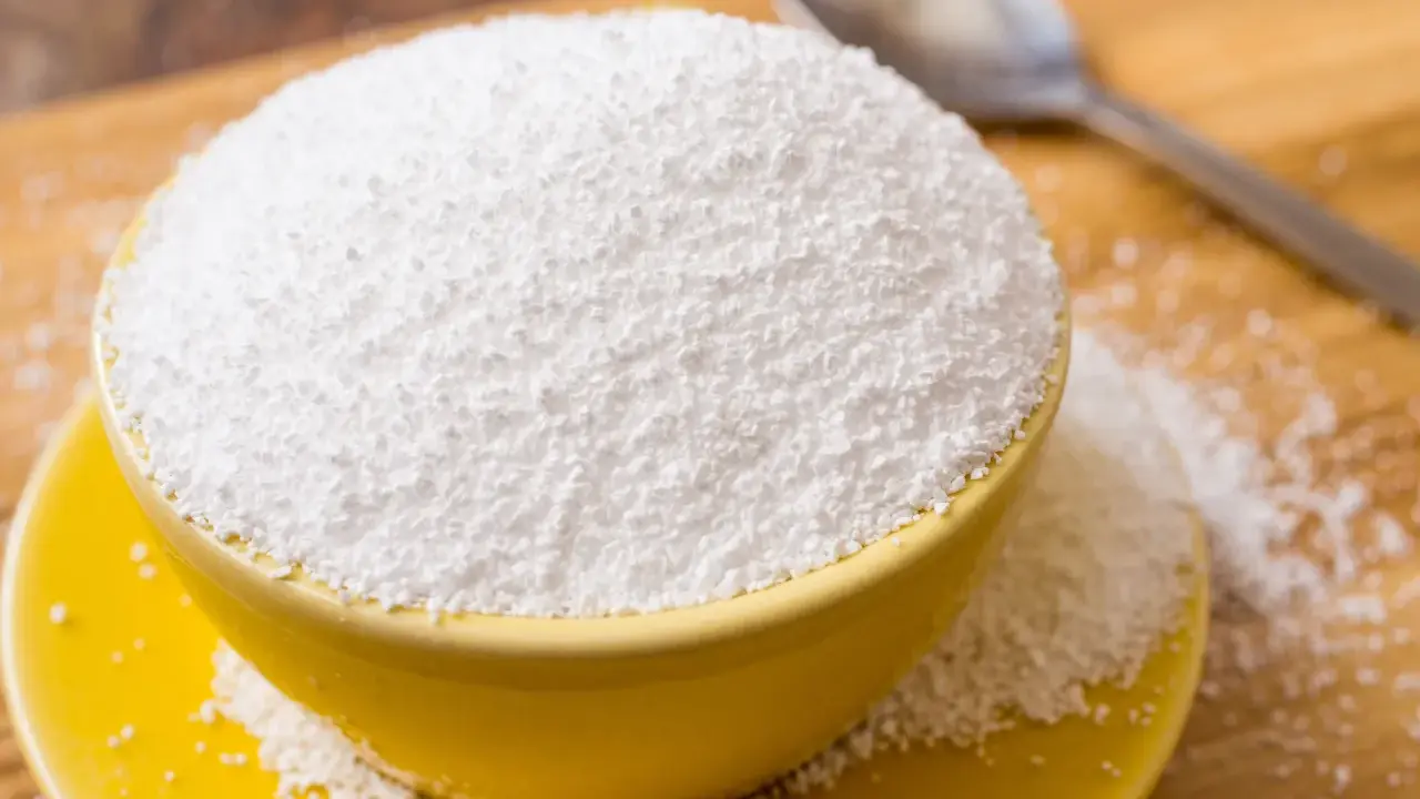 Tazón amarillo lleno de polvo blanco, posiblemente sorbitol. Cuidado con los alimentos prohibidos que lo contienen.