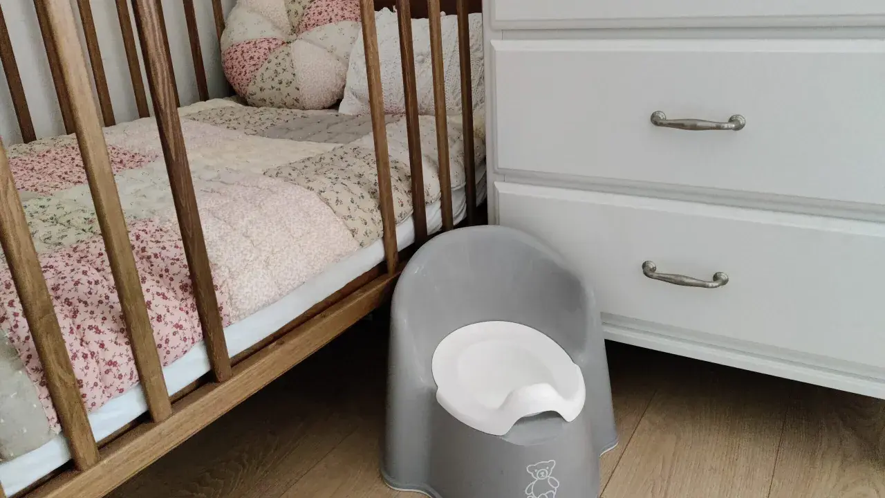 Szara nocniczka BabyBjörn obok łóżeczka. Czas na rozwiązanie problemu z odpieluchowaniem 3 latka.