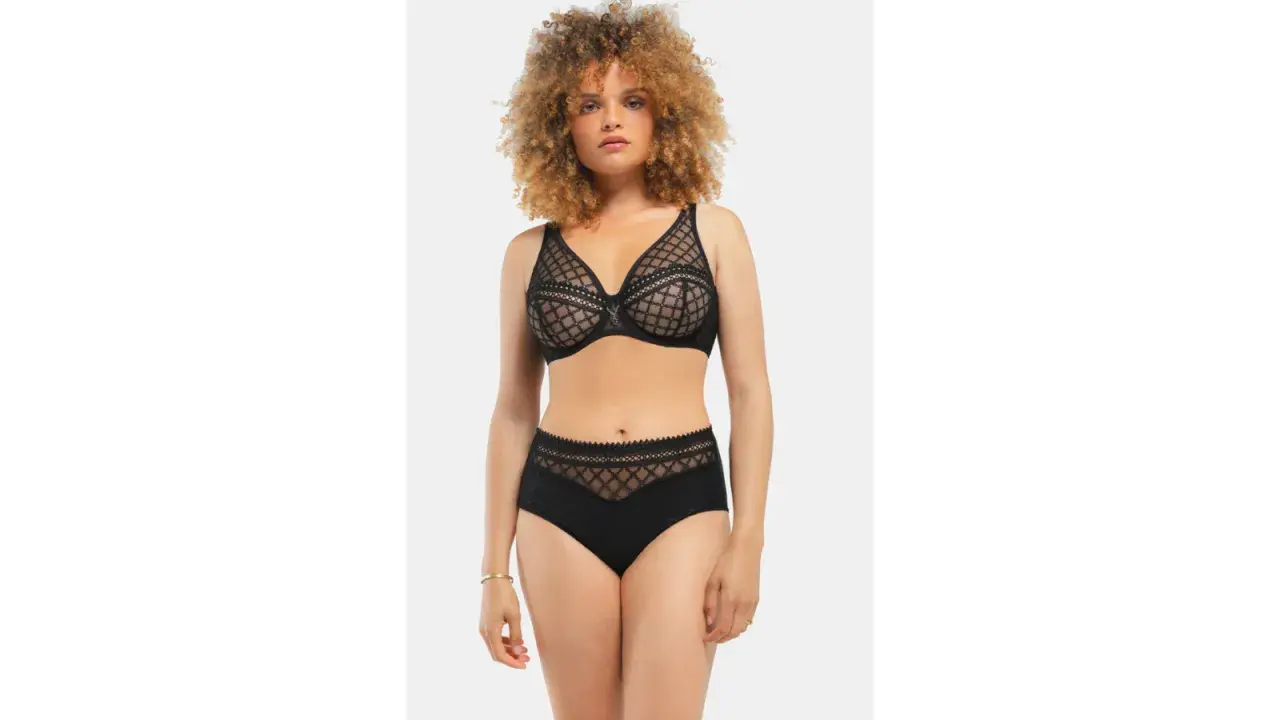 Modella con un seno largo indossa un completo intimo nero in pizzo trasparente.