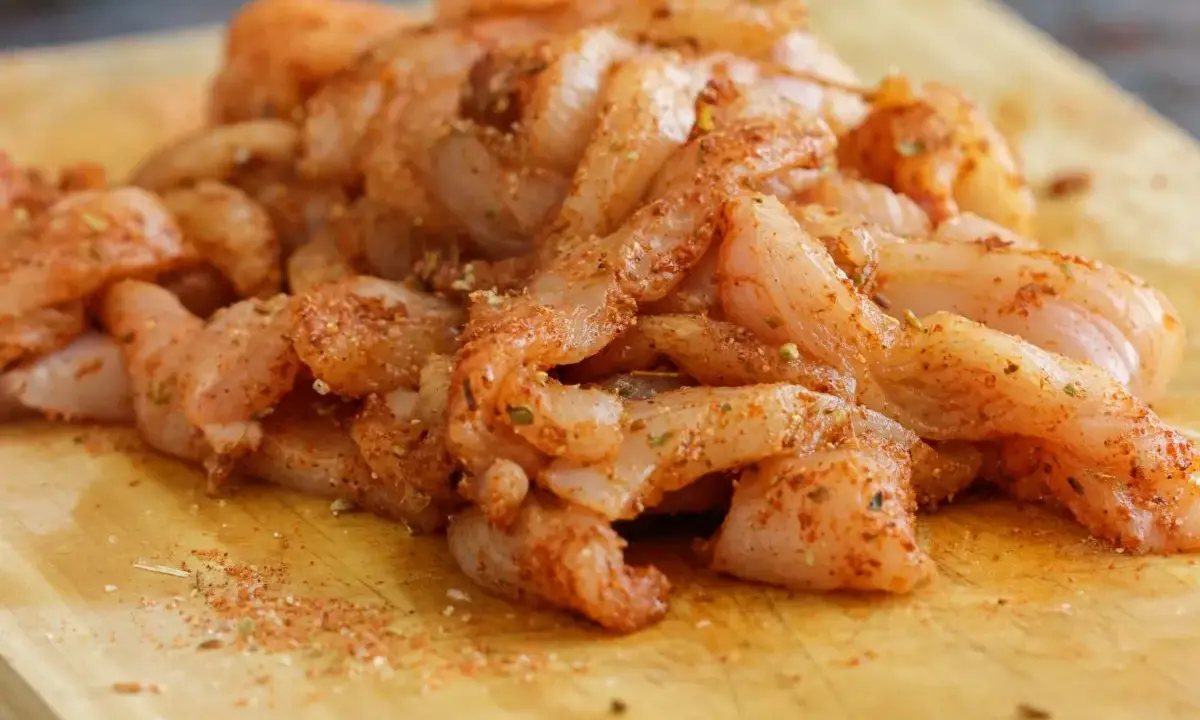 Tiras de pollo crudo sazonadas, listas para preparar unas deliciosas fajitas de pollo.