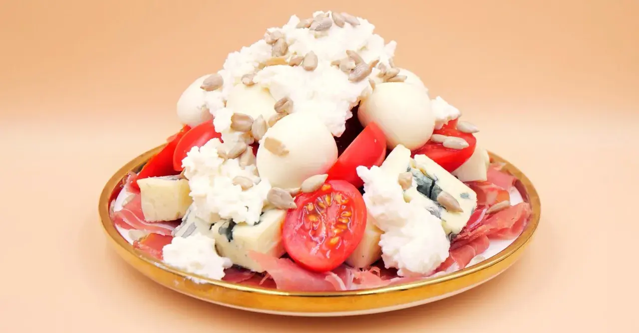 Wykwintna sałatka z szynką parmeńską, serami pleśniowymi, pomidorkami i słonecznikiem.