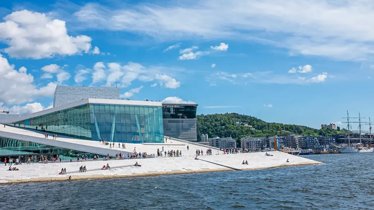 Ein sonniger Tag für Oslo Sightseeing am Opernhaus mit seiner einzigartigen Architektur und dem Wasser.