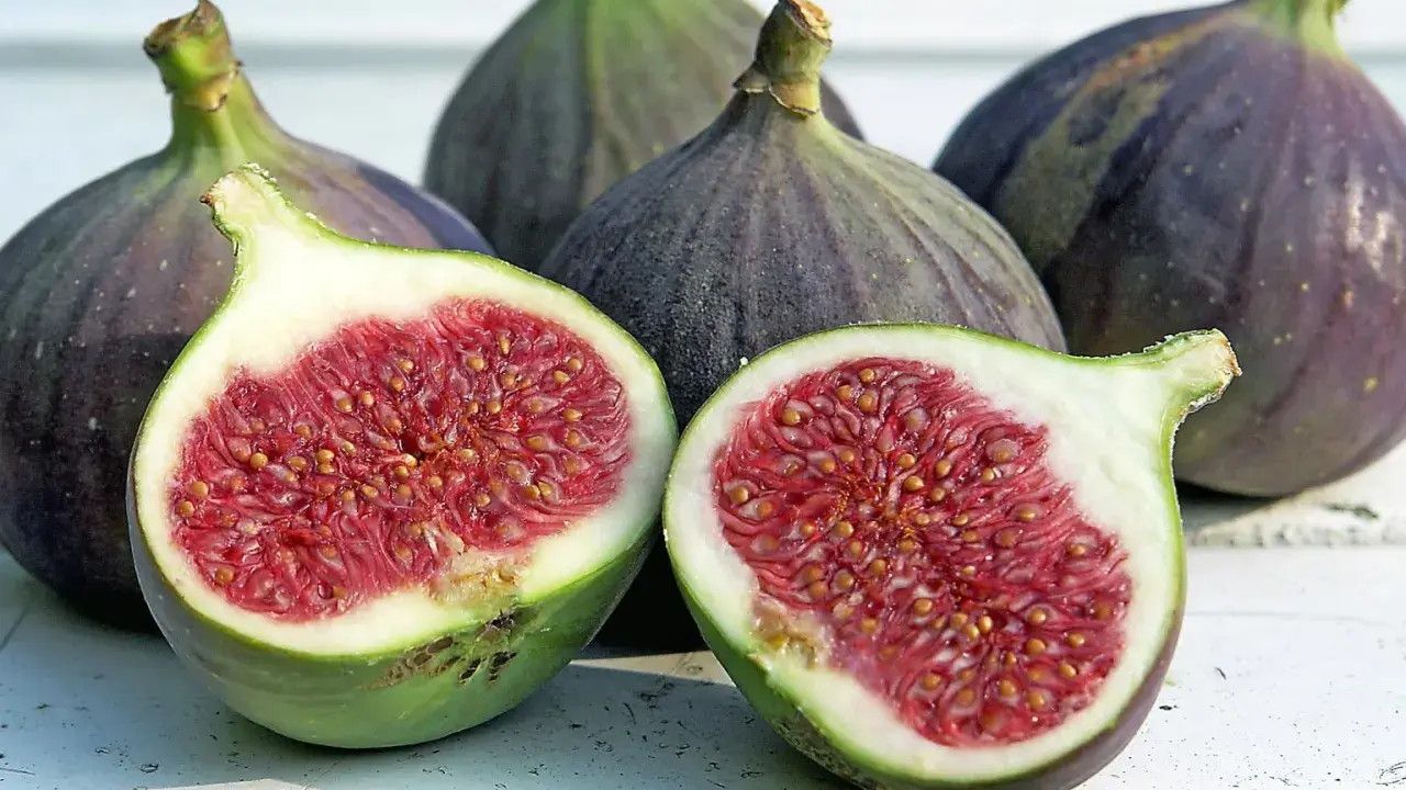 Frische Feigen, eine aufgeschnitten, zeigen ihr saftiges Inneres. Sie sind feigen gesund und ein Genuss.