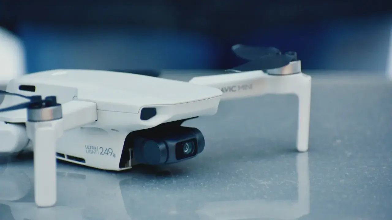 Biały dron Mavic Mini, ważący 249g, gotowy do rejestracji obrazu.